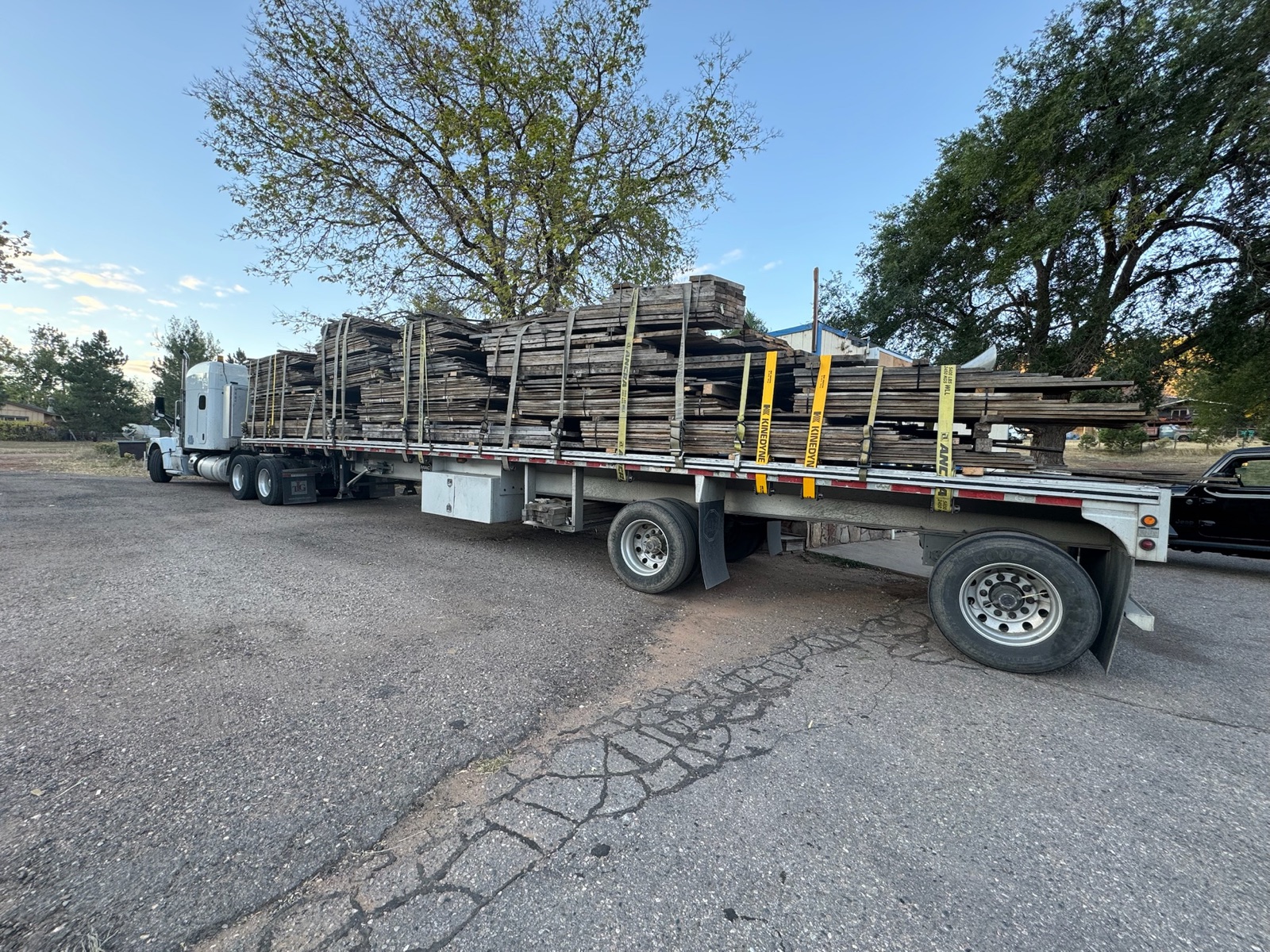 Flatbed truck loaded with bundled reclaimed lumber for delivery